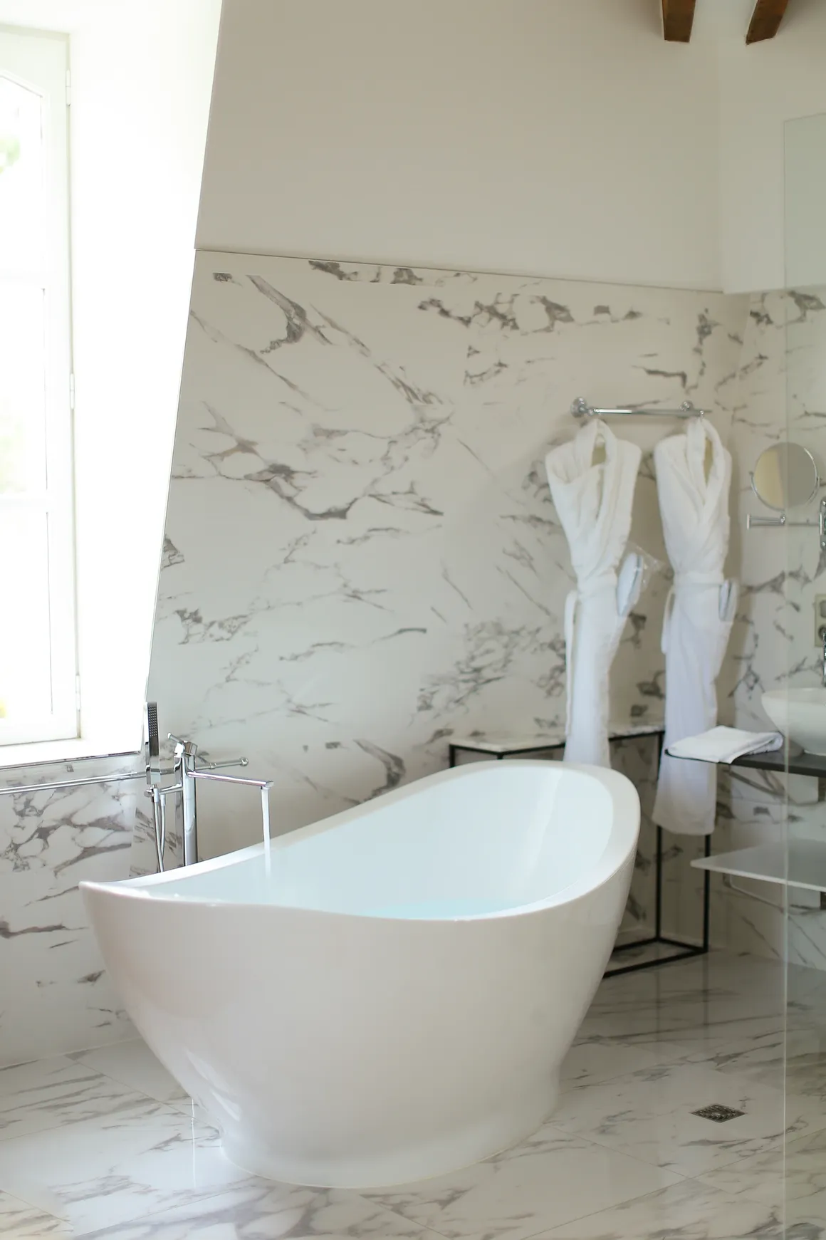 Modern bathroom with glass-enclosed shower, double vanity, and white cabinetry
