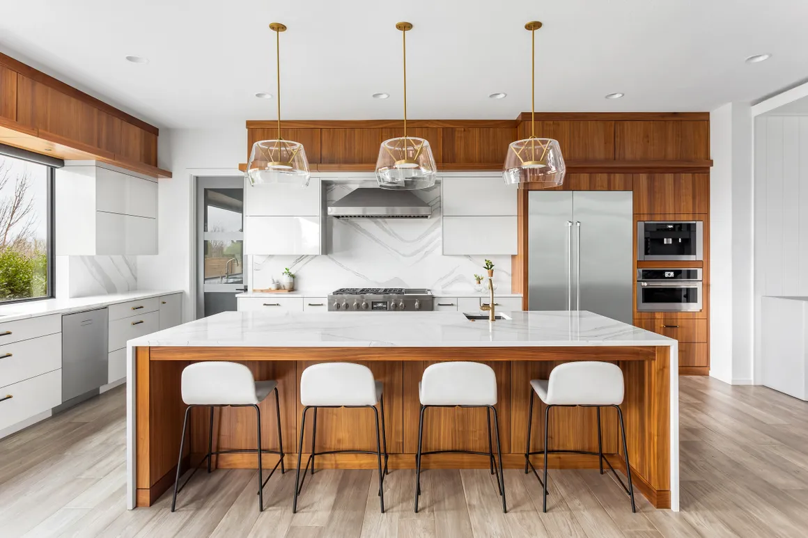 Modern kitchen remodel with large island, pendant lights, and white cabinetry