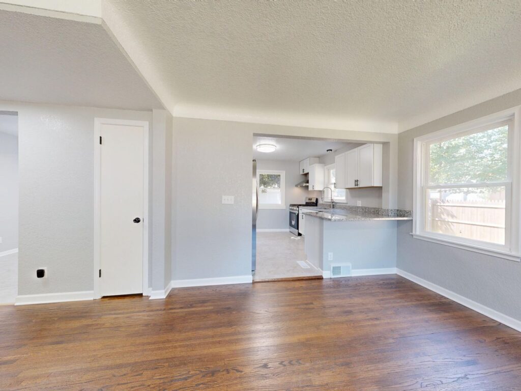 Modern kitchen and dining area with hardwood floors and natural light.