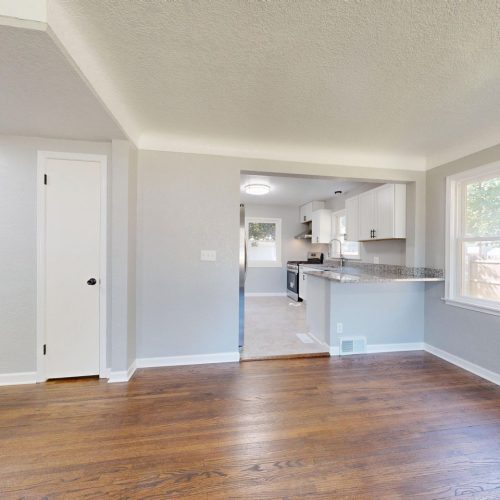Modern kitchen and dining area with hardwood floors and natural light.
